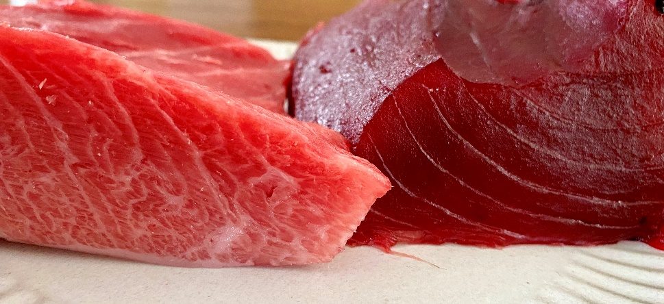 Close-up of dry aged tuna cuts showing fatty belly and deep red loin